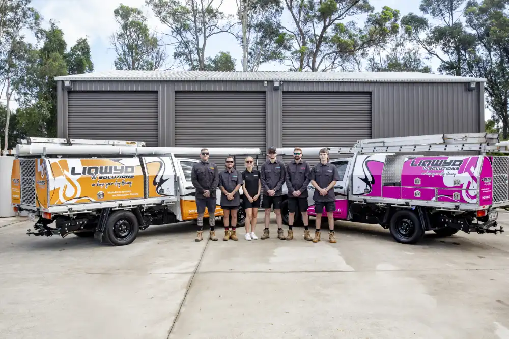 Lyqwyd Solutions employees standing next to work vehicles